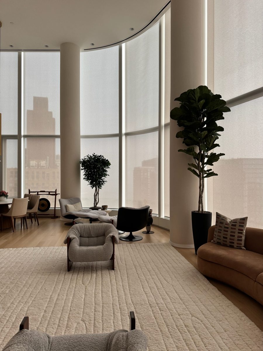 Coupled motorized roller shades spanning curved floor to ceiling glazing