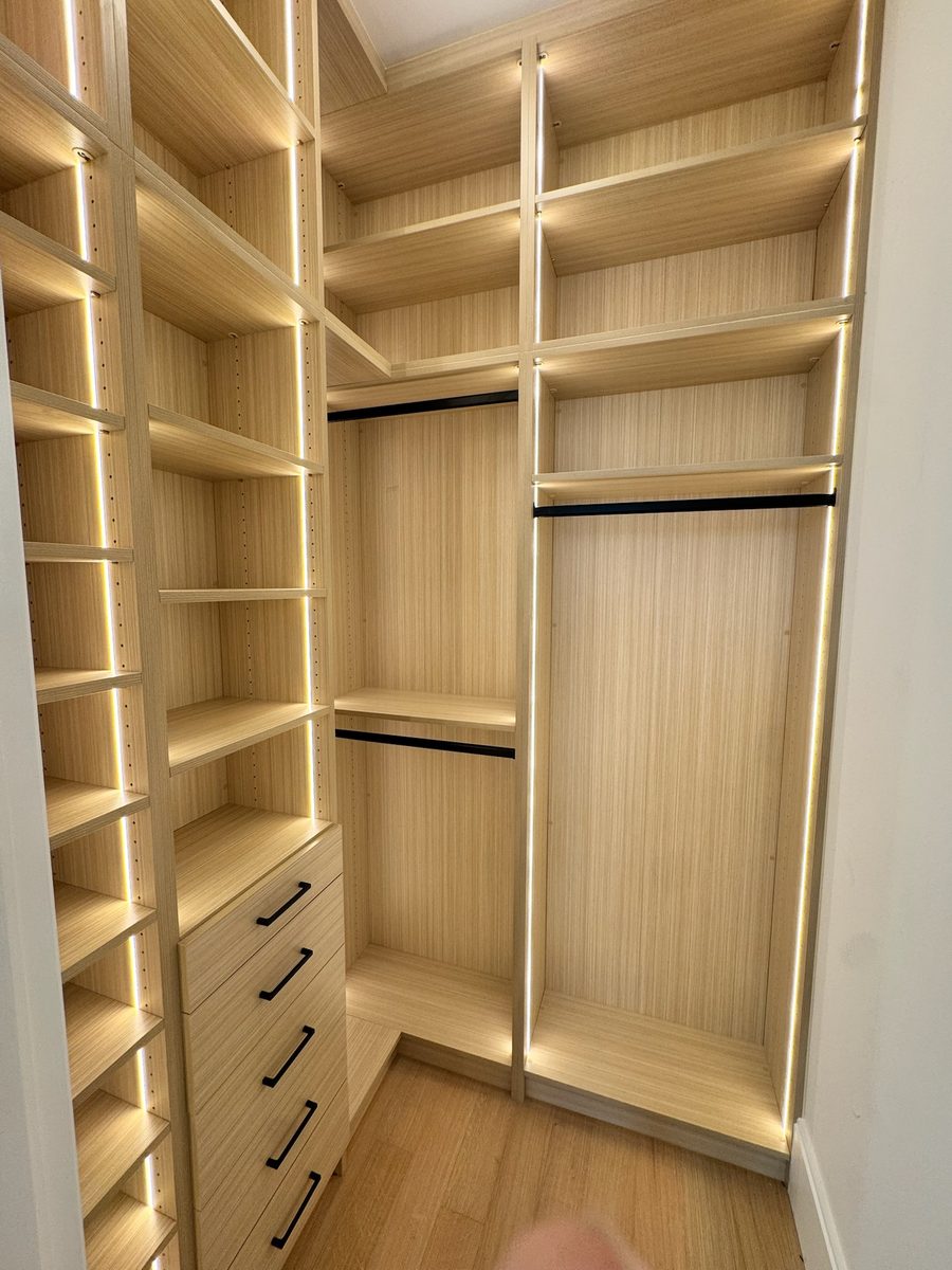 Walk in closet system in woodgrain TFL with corner return and integrated LED strip lighting